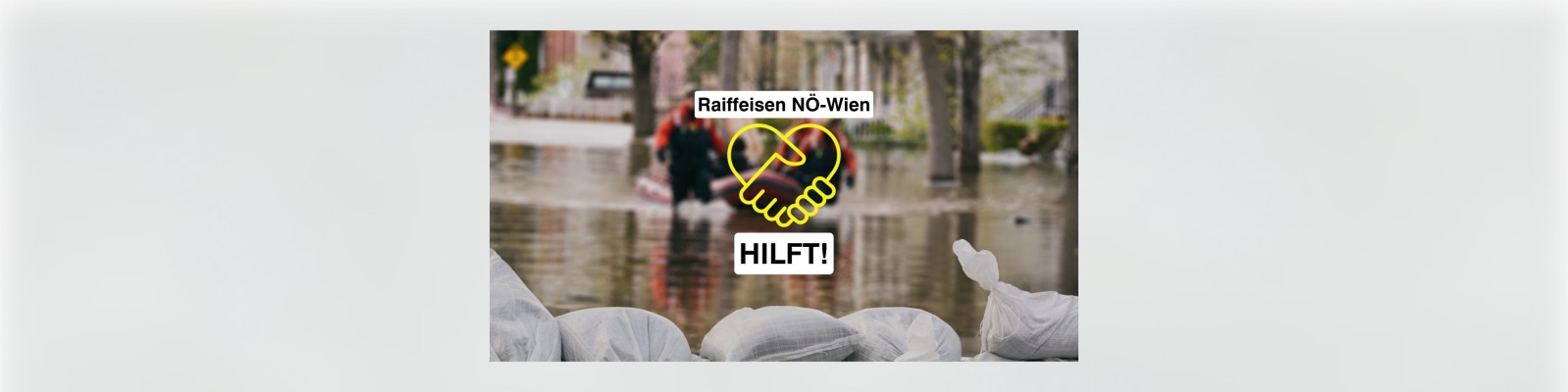 Sandsäcke im Vordergrund, Rettungskräfte in einer überfluteten Straße und eine Raiffeisen NÖ-Wien Hilfsbotschaft als Overlay.